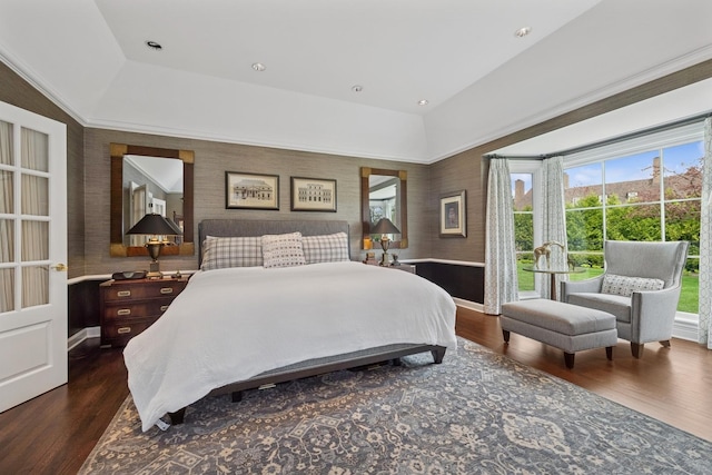 bedroom featuring baseboards, dark wood-style floors, and a raised ceiling
