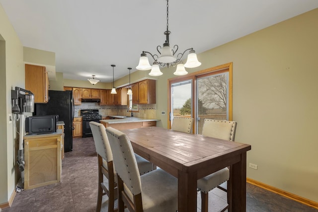 dining area featuring baseboards and a notable chandelier