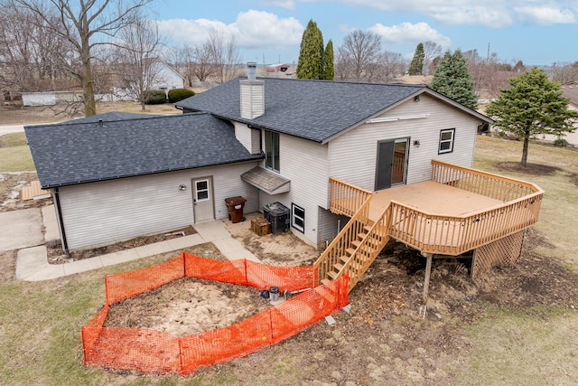 rear view of property featuring a chimney, a wooden deck, cooling unit, a shingled roof, and stairs