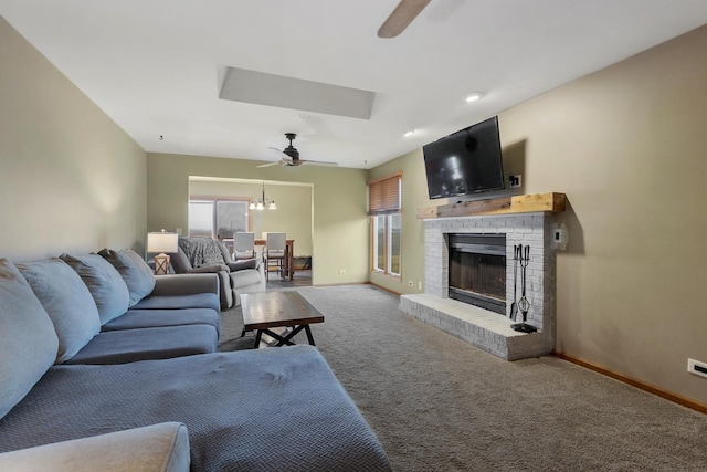 living room featuring a ceiling fan, baseboards, carpet, and a fireplace
