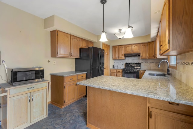 kitchen with decorative backsplash, a sink, light stone counters, black appliances, and a peninsula