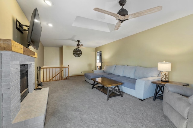 living area with carpet flooring, a ceiling fan, and a brick fireplace