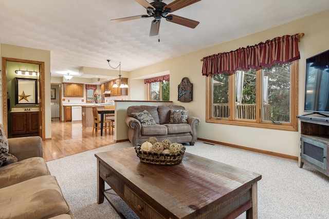 living area featuring baseboards, visible vents, a ceiling fan, and light colored carpet