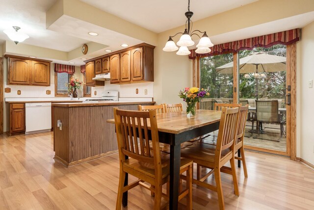 dining space with recessed lighting, a notable chandelier, and light wood finished floors