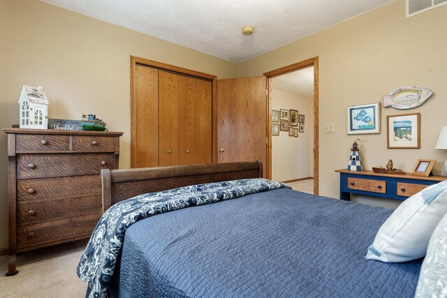 carpeted bedroom featuring visible vents and a closet