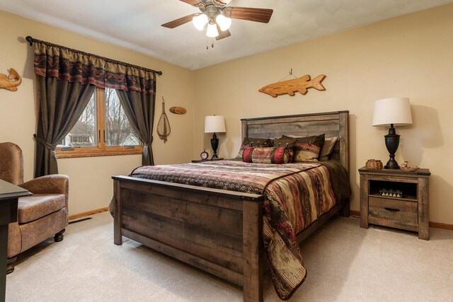 bedroom with light colored carpet, a ceiling fan, baseboards, and visible vents