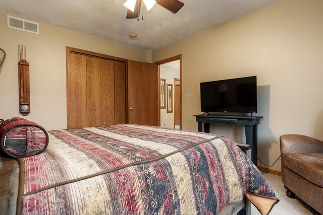 carpeted bedroom featuring baseboards, ceiling fan, a closet, and visible vents