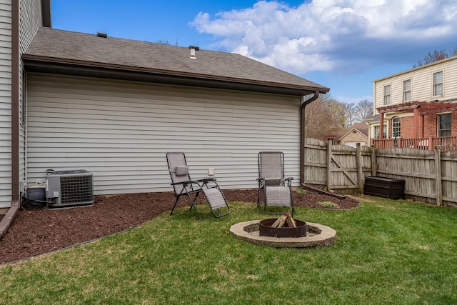 view of yard with fence, cooling unit, and a fire pit