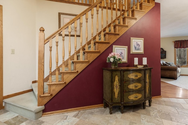 stairs with baseboards and stone tile floors