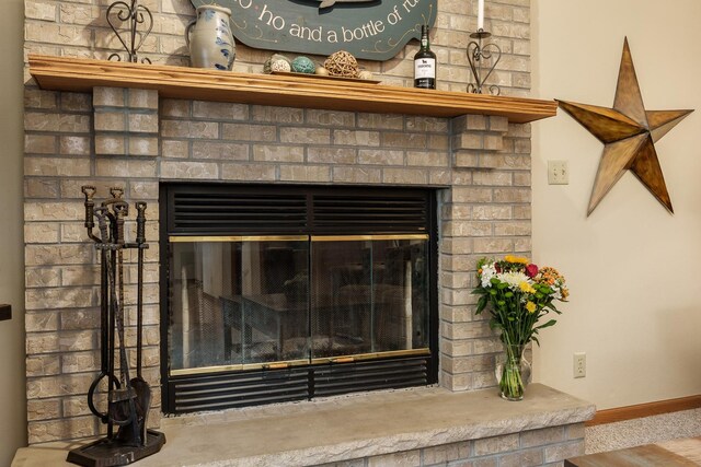 room details with baseboards and a brick fireplace
