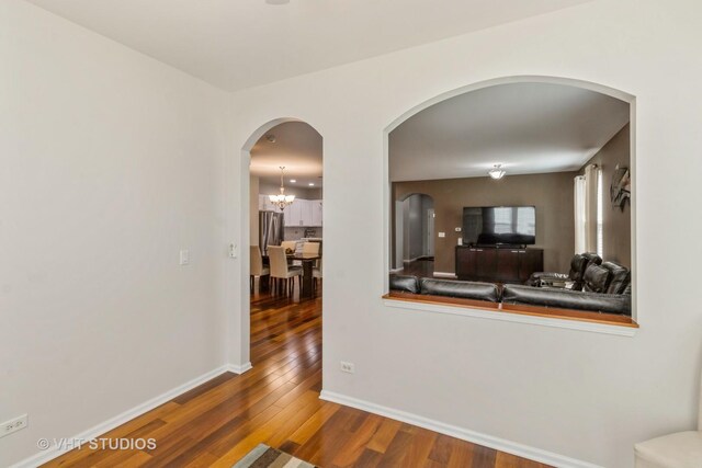 1674 Francis Dr, Pingree Grove, IL 60140 - living room featuring arched walkways, wood finished floors, baseboards, and a chandelier