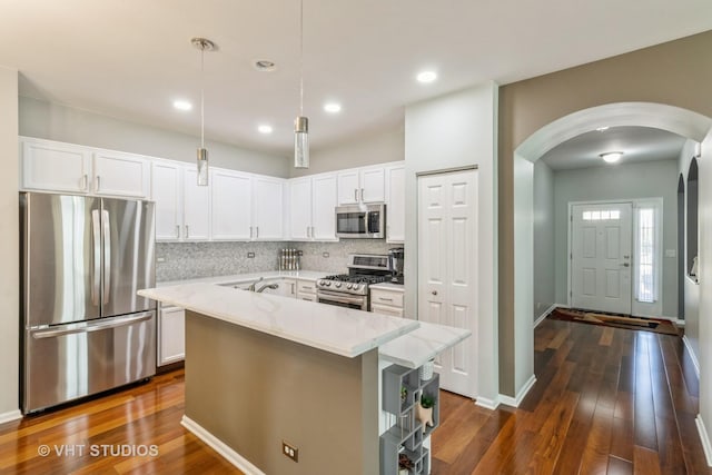 1674 Francis Dr, Pingree Grove, IL 60140 - kitchen featuring stainless steel appliances, arched walkways, decorative backsplash, white cabinetry, and dark wood-type flooring