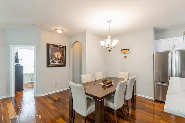 1674 Francis Dr, Pingree Grove, IL 60140 - dining area with arched walkways, a chandelier, dark wood-type flooring, and baseboards