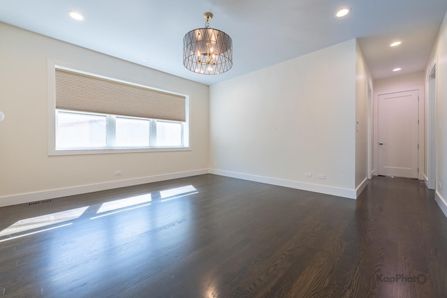 empty room featuring visible vents, baseboards, recessed lighting, dark wood-type flooring, and a chandelier