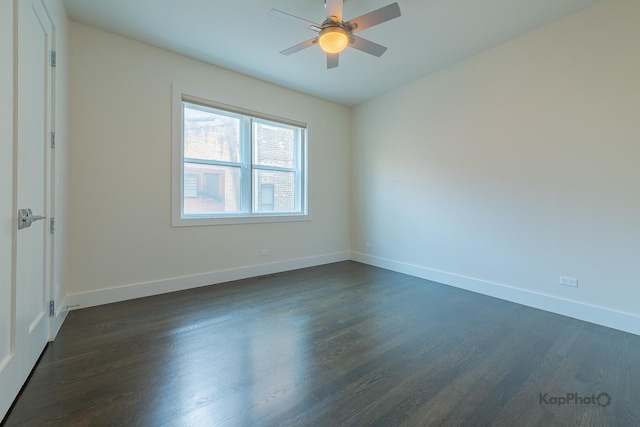 empty room featuring baseboards, a ceiling fan, and dark wood-style floors