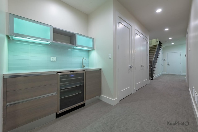 bar featuring light colored carpet, baseboards, indoor wet bar, beverage cooler, and recessed lighting