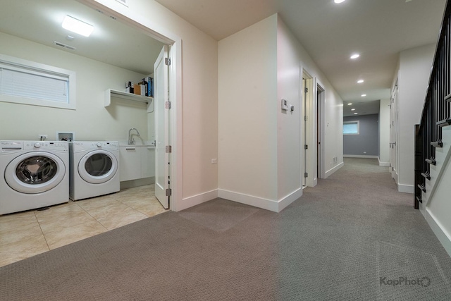 clothes washing area with laundry area, visible vents, light carpet, and a sink