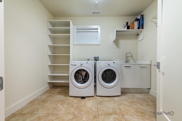 laundry area with laundry area, visible vents, washer and dryer, baseboards, and a sink