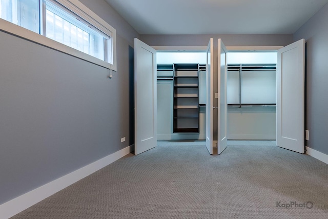 unfurnished bedroom featuring carpet flooring, baseboards, and two closets