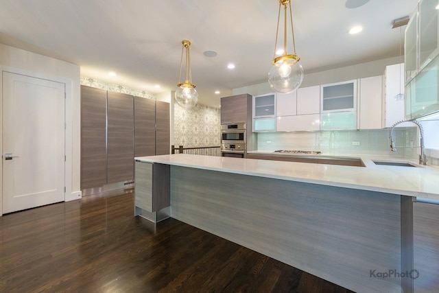 kitchen with glass insert cabinets, modern cabinets, dark wood-type flooring, a sink, and backsplash