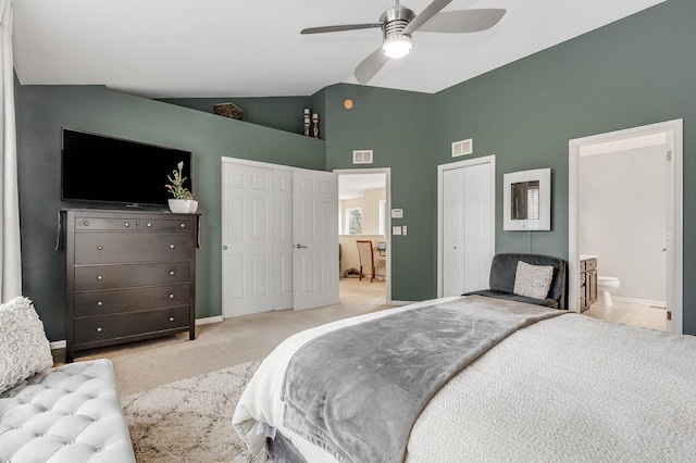 bedroom featuring light colored carpet, high vaulted ceiling, two closets, baseboards, and visible vents