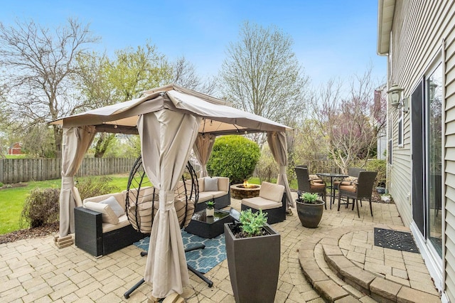 view of patio with a fenced backyard, an outdoor living space with a fire pit, outdoor dining space, and a gazebo