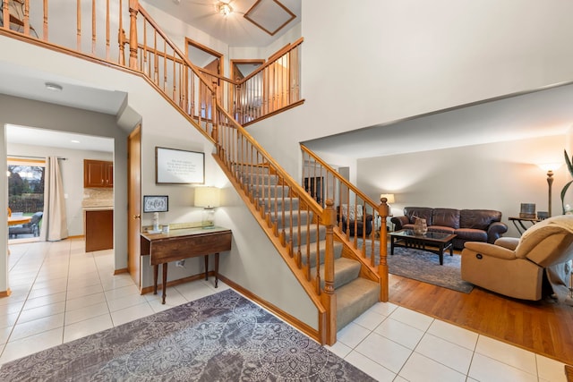 2739 Genoa Dr, New Lenox, IL 60451 - staircase featuring tile patterned floors, a towering ceiling, and baseboards