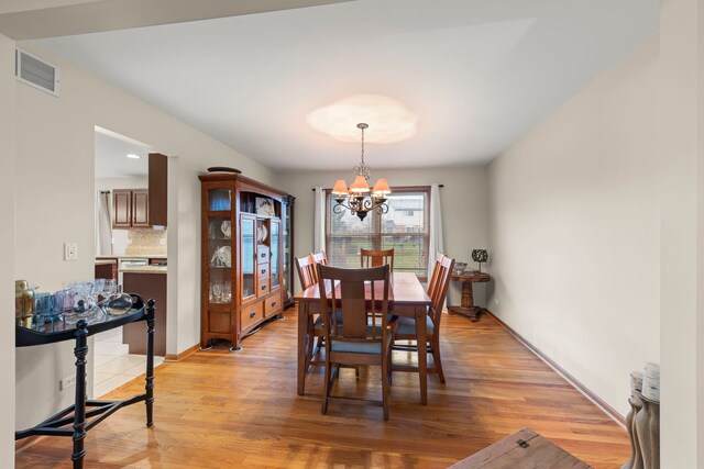 2739 Genoa Dr, New Lenox, IL 60451 - dining area with a chandelier, light wood finished floors, and baseboards