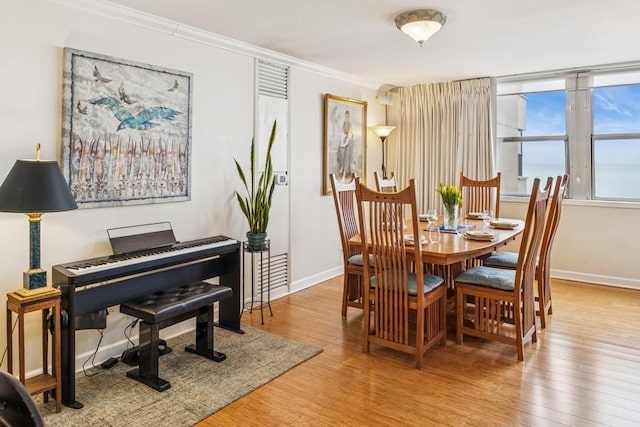 dining room featuring baseboards, ornamental molding, and wood finished floors