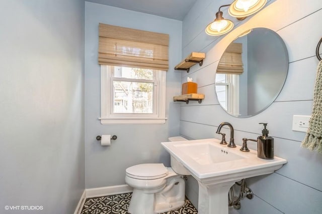 half bathroom featuring toilet and baseboards