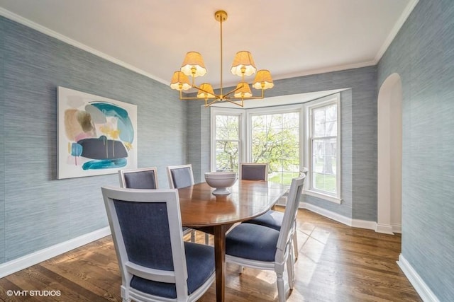 dining space featuring ornamental molding, a notable chandelier, baseboards, and wallpapered walls