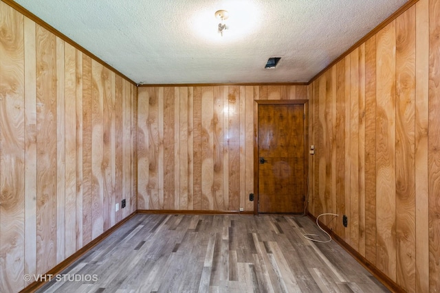 21822 Merrill Ave, Sauk Village, IL 60411 - spare room with a textured ceiling, wood finished floors, wooden walls, baseboards, and crown molding