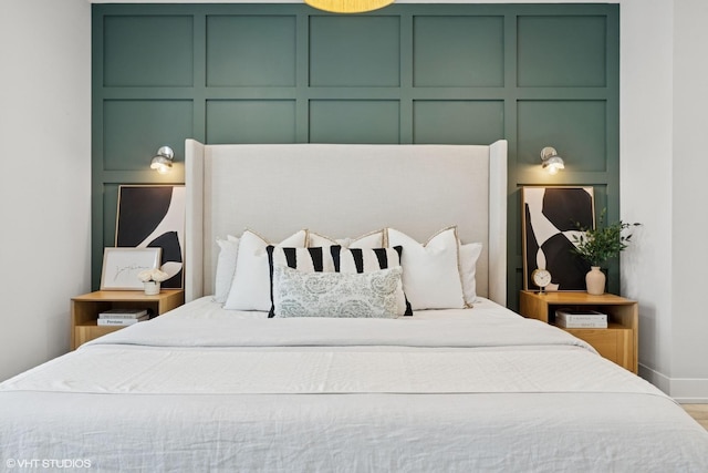 bedroom with baseboards and a decorative wall
