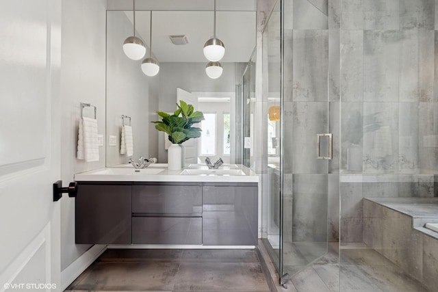 bathroom with double vanity, visible vents, a sink, and a stall shower