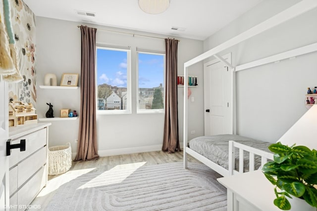 bedroom with visible vents, baseboards, and light wood-type flooring