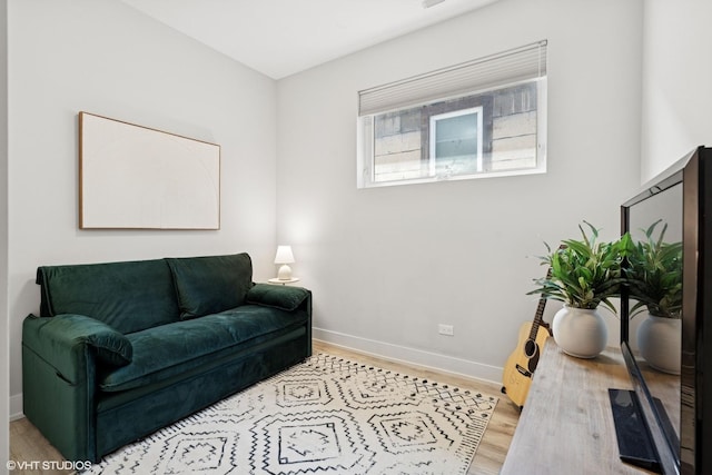 living area featuring baseboards and wood finished floors