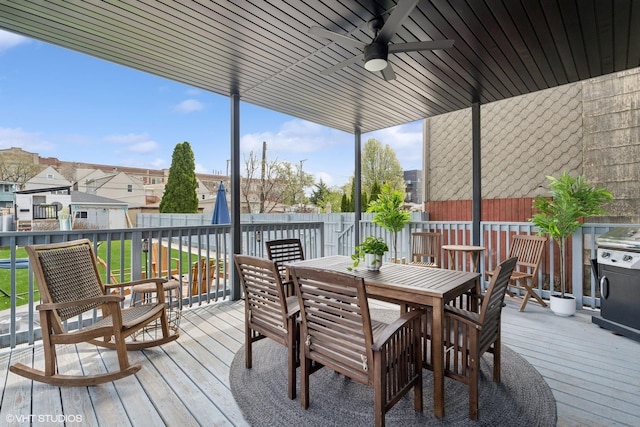 wooden deck featuring a ceiling fan, a fenced backyard, a residential view, and outdoor dining space