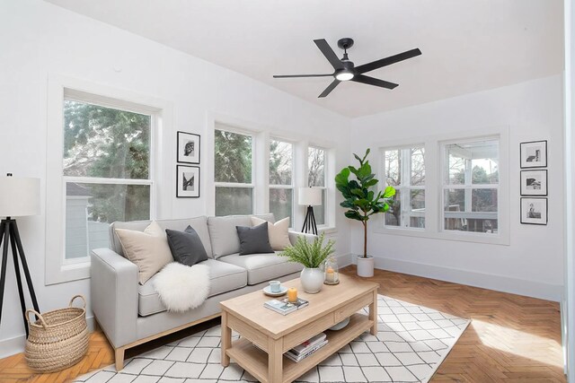 living room featuring baseboards and ceiling fan