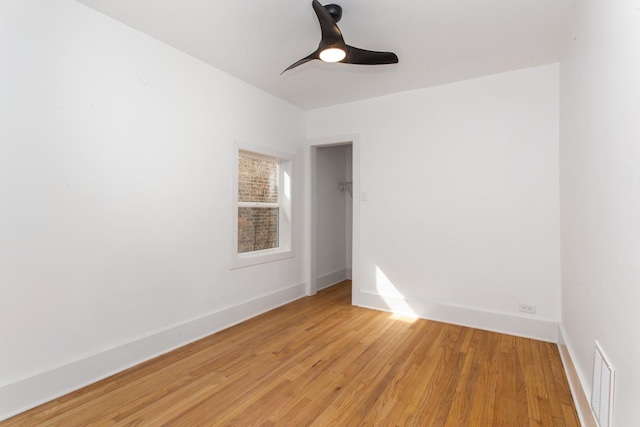 empty room with a ceiling fan, baseboards, visible vents, and light wood-style floors