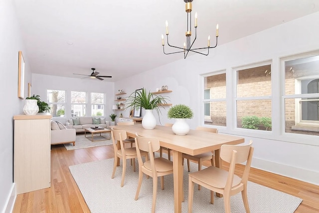 dining room with light wood-style floors and ceiling fan with notable chandelier