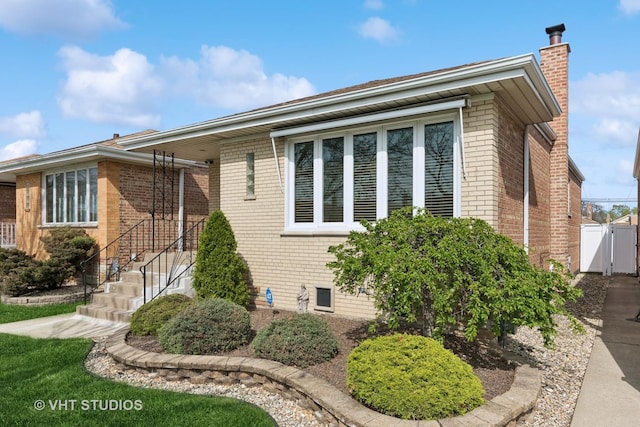 6223 S Rutherford Ave, Chicago, IL 60638 - view of property exterior with brick siding, fence, a chimney, and a gate