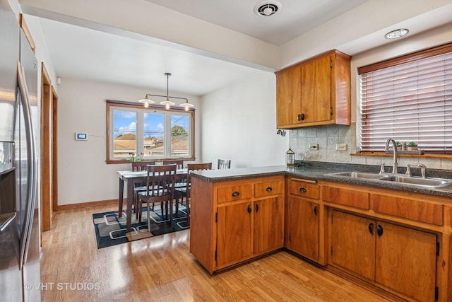 6223 S Rutherford Ave, Chicago, IL 60638 - kitchen with freestanding refrigerator, brown cabinets, a sink, and light wood-style floors