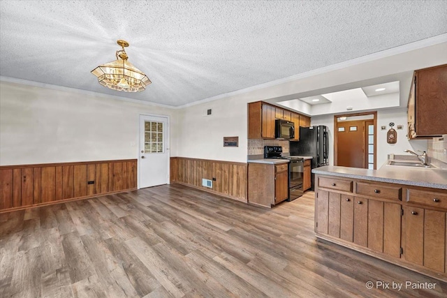 kitchen featuring a textured ceiling, wood finished floors, and black appliances