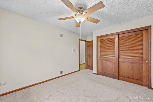 unfurnished bedroom featuring visible vents, carpet flooring, baseboards, and a closet