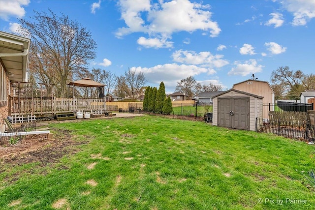 view of yard with a gazebo, an outbuilding, a fenced backyard, and a storage unit