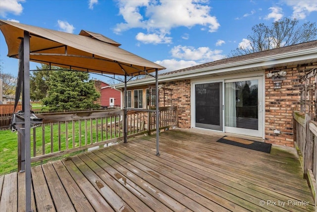 wooden deck featuring a gazebo and a yard