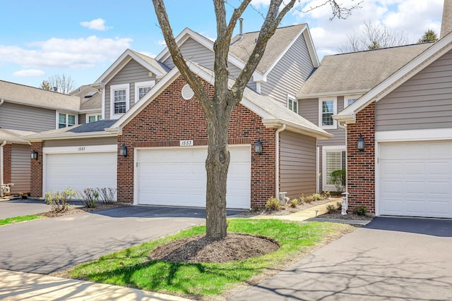 view of front of property featuring brick siding, roof with shingles, and driveway