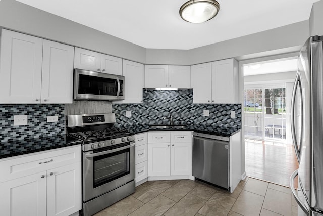 kitchen featuring a sink, white cabinetry, dark countertops, and stainless steel appliances