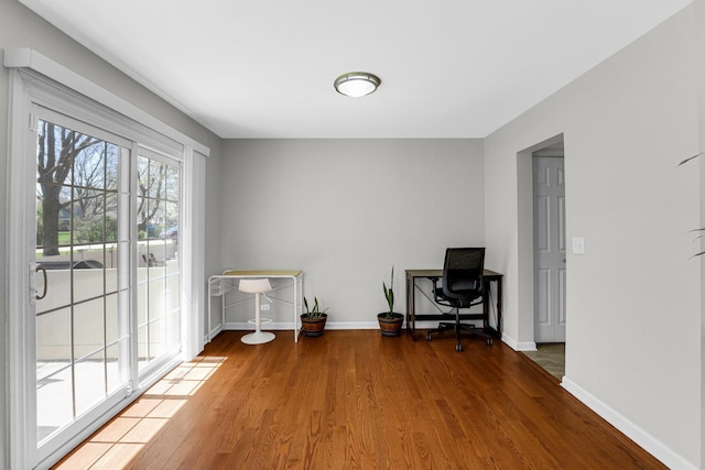 home office featuring baseboards and wood finished floors