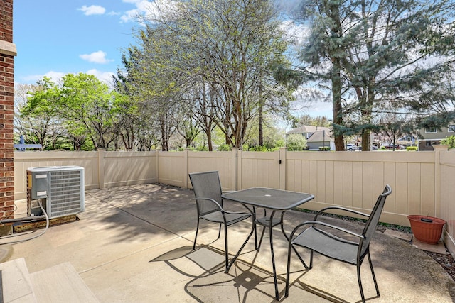 view of patio / terrace with a fenced backyard, central AC unit, and outdoor dining space